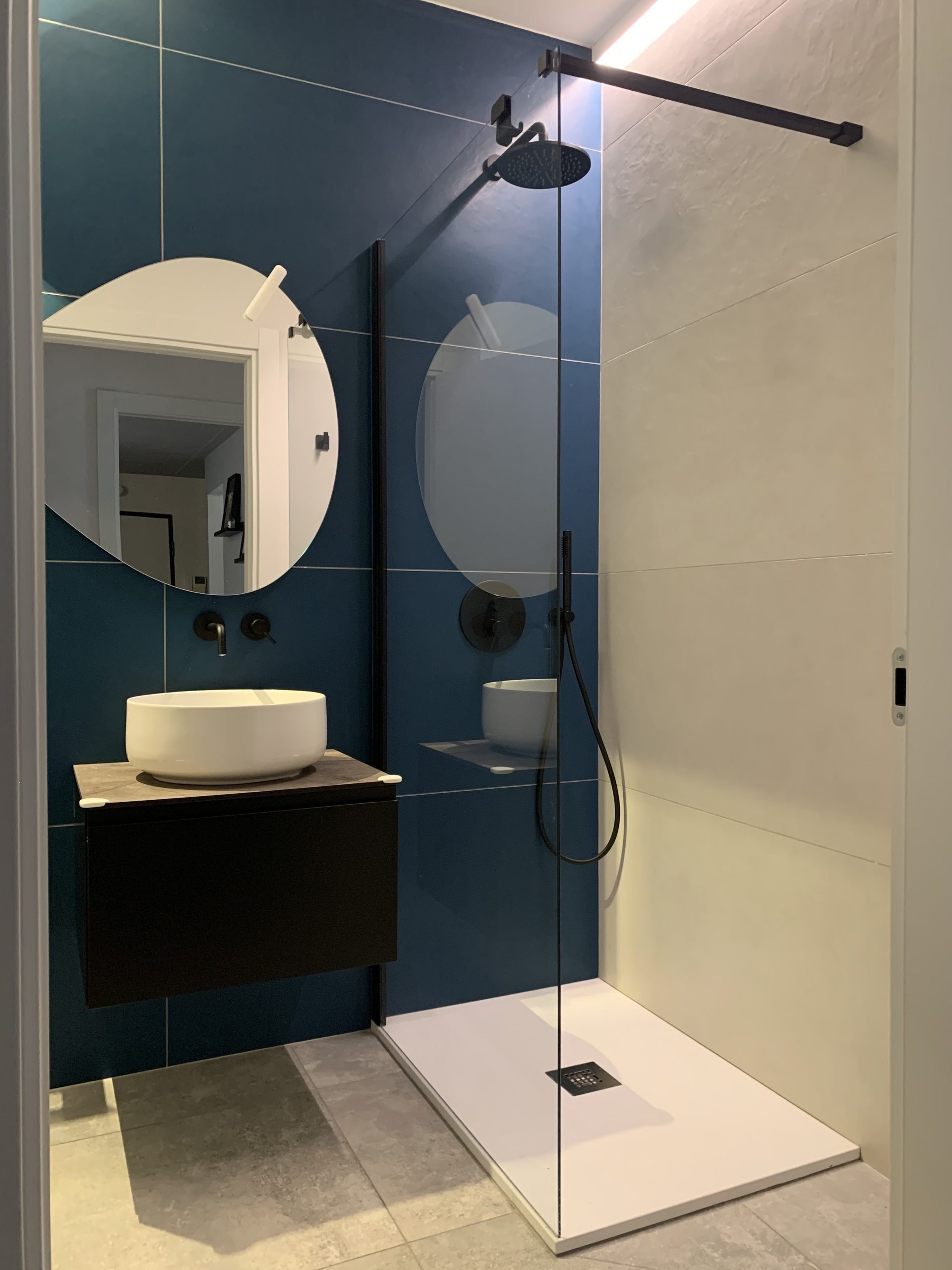 Primo bagno ristrutturato nei toni del blu con illuminazione radente